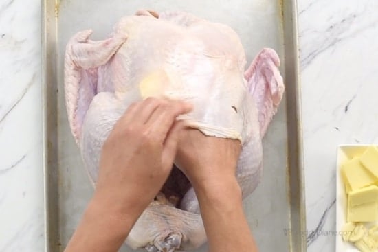 Sliding butter under the skin of the turkey