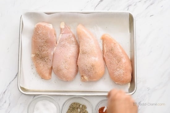 Seasoning raw chicken breasts