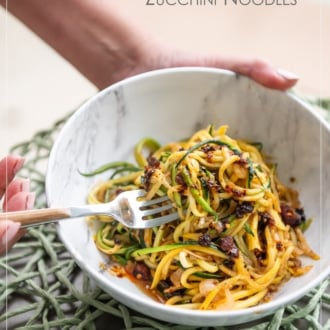 chili crunch zucchini noodles with fork holding bowl