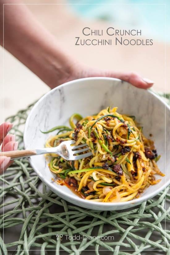 chili crunch zucchini noodles with fork holding bowl 