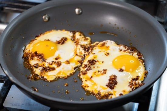 Chili crisp over eggs in pan