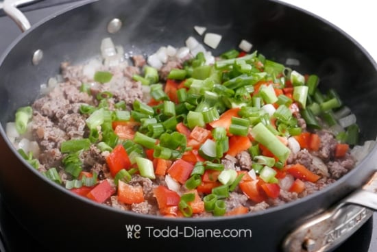 adding onion and bell pepper to meat mix