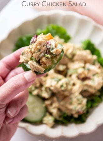 Holding cucumber with curry chicken salad