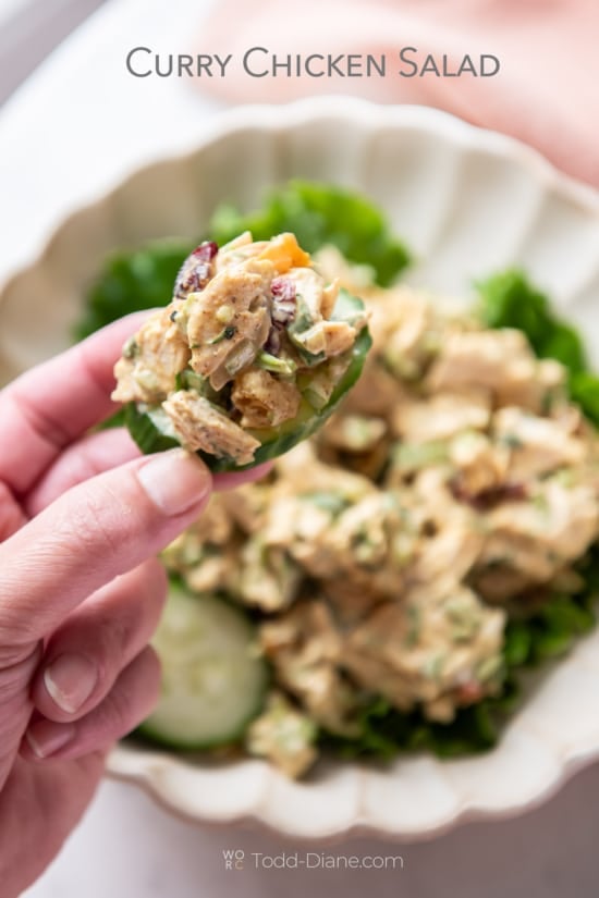 Holding cucumber with curry chicken salad