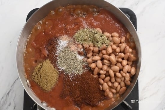 seasonings, spices and beans added to chili pot