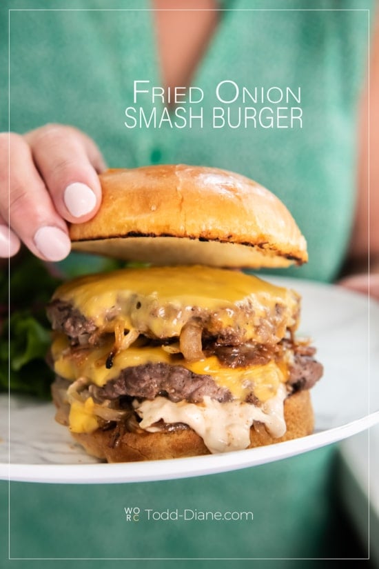 adding bun to top of fried onion burger