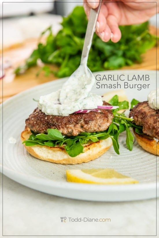 adding yogurt tzatziki to lamb smash burger
