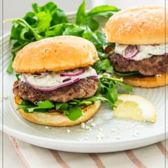 loaded garlic lamb smash burgers on plate with arugula