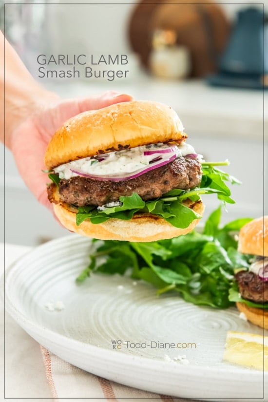 holding greek garlic lamb smash burger in hand 
