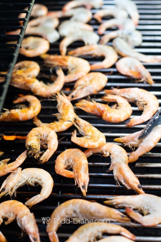grilling prawns on bbq by white on rice couple