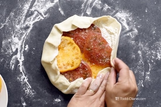 Wrapping edges of dough around tomato slices