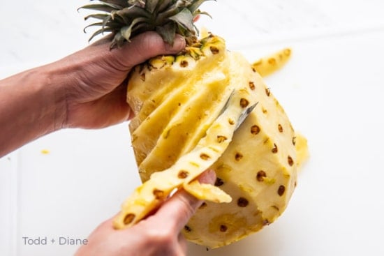 stripping rows of pineapple eyes