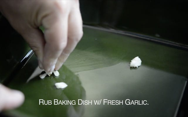 Rubbing garlic on baking dish