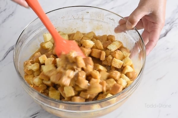 Stirring bread into pumpkin mixture