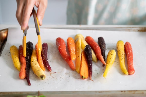 Spreading carrots on baking sheet pan