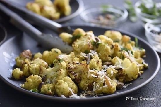Grabbing finished curried cauliflower with tongs