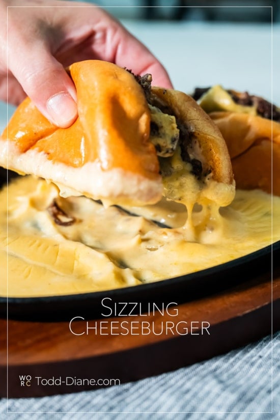 holding sizzling cheeseburger
