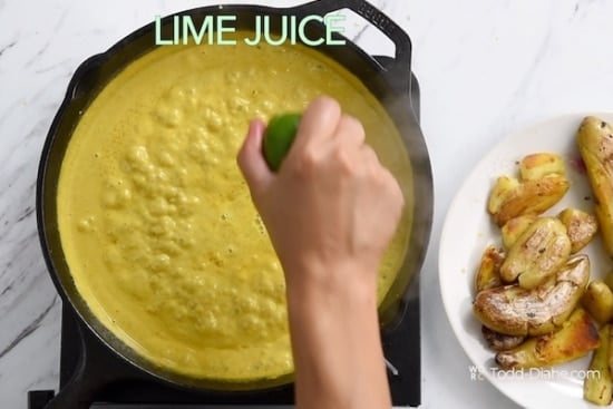 Squeezing lime juice over curry sauce