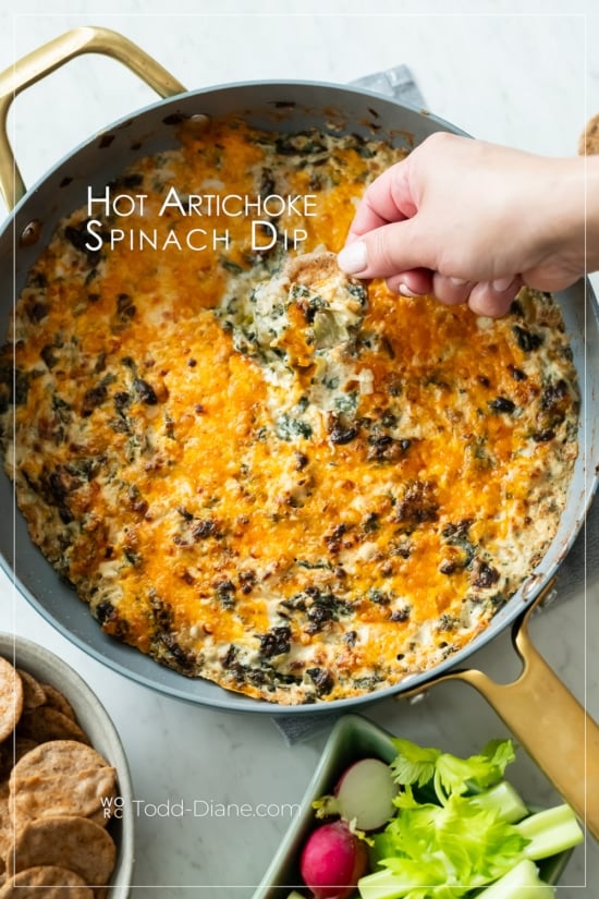 dipping into hot stovetop artichoke spinach dip