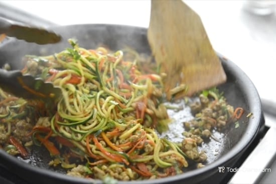 Stirring zoodles with sauce