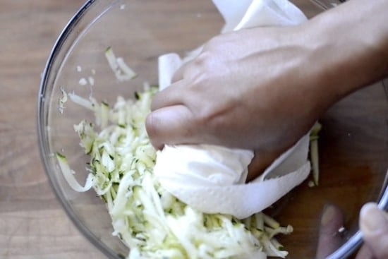 Squeezing grated zucchini with paper towel