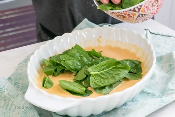 adding spinach to curry sauce