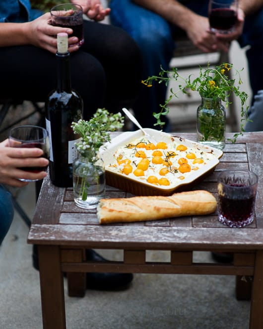 Baked tomato goat cheese dip with ricotta cheese in a serving dish on a table