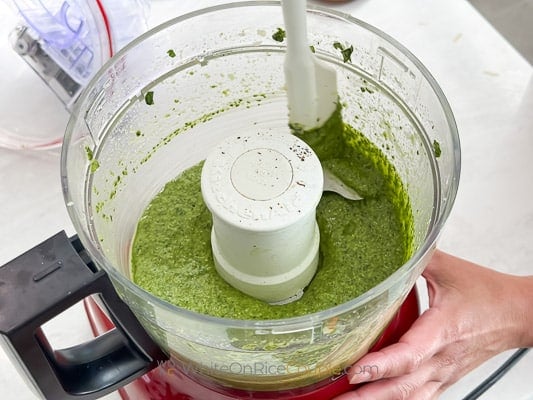 scraping sides of pesto bowl