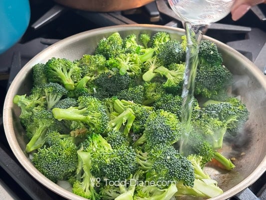 adding water to broccoli pan