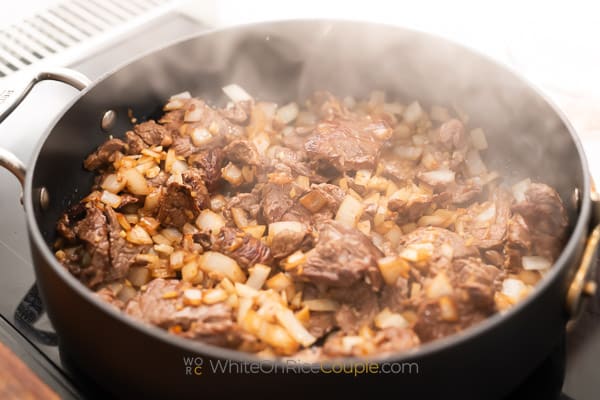 cooking down the onions and garlic in meat