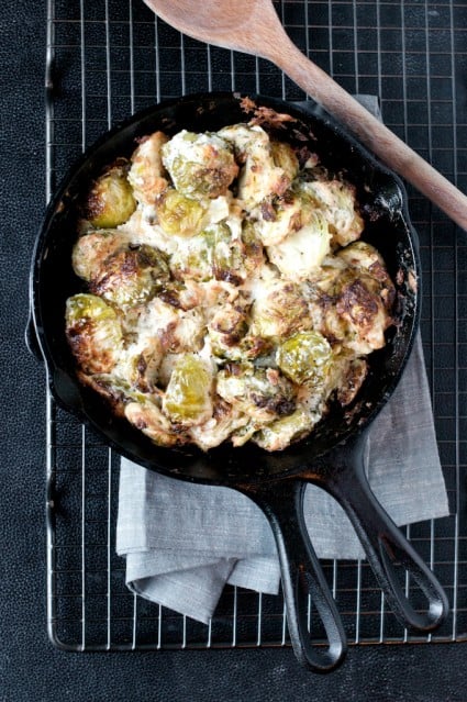 Cheesy Baked Brussels Sprouts Recipe with Parmesan Cheese and Onion in a skillet