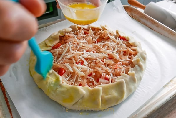 brushing edges of pie dough with egg or butter