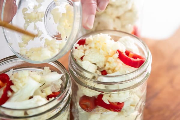 adding garlic to pickles
