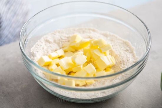 Cubes of butter in bowl with flour