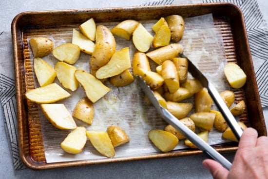 Tossing half cooked potatoes with tongs