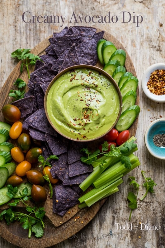 Creamy Avocado Dip and Avocado Dressing on a platter with tortilla chips and veggies