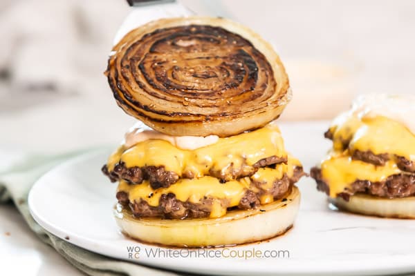 adding onion top to cheeseburger