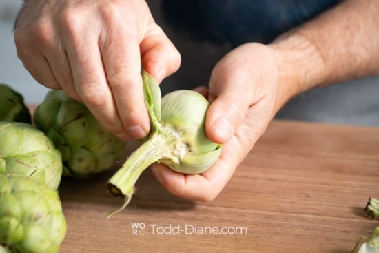 stripping away artichoke leaves