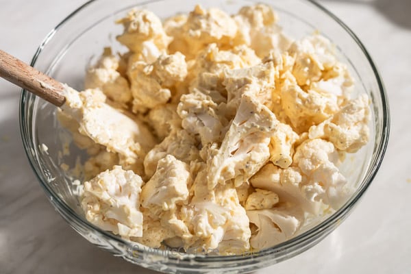 coating cauliflower with cheese mixture