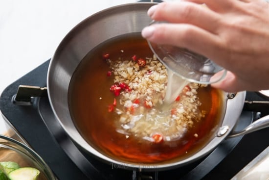 Adding sauce ingredients to a pan