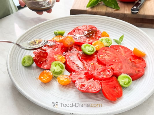drizzling dressing on tomatoes