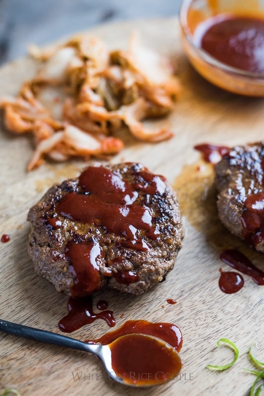 Korean Kimchi Burgers with Gochujang Sauce close up on a cutting board