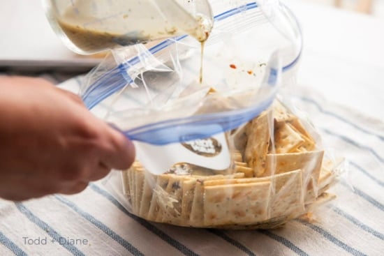 Pouring seasoning over crackers