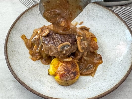 Serving salisbury steak and gravy over smashed potatoes