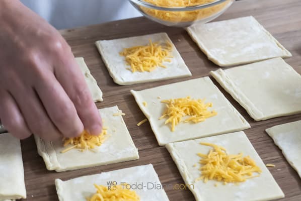 adding cheese to top of puff pastry dough