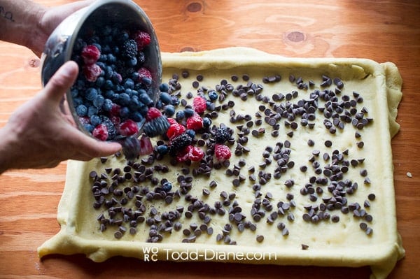 Chocolate chips and berries on dough