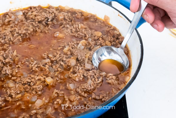 skimming the fat off the meat mix