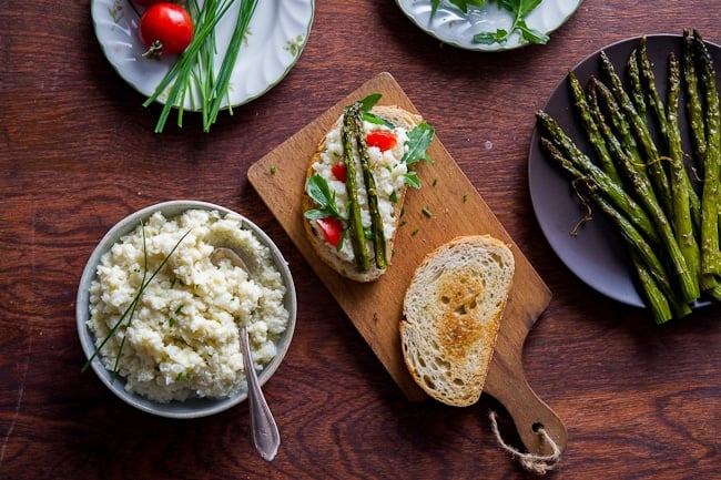 Smashed cauliflower sandwich recipe with roasted asparagus on a cutting board