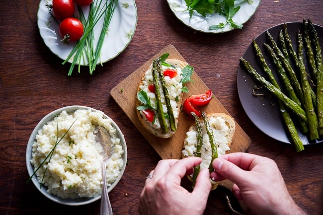 Smashed cauliflower sandwich recipe with roasted asparagus on a cutting board