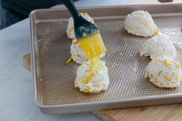 brushing melted butter or egg over raw biscuits